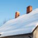 In winter seasons a house roof covered in snow